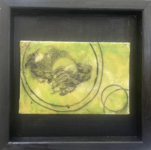 Artwork portraying a black cloud graphic in the center right of the piece on a yellow/green background encircled by two concentric black circles. Two additional circles are in the bottom right corner.